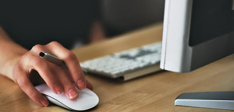 person holding apple magic mouse
